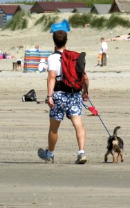 walker with dog, East Wittering, Sussex. Ruth walking round the coast.