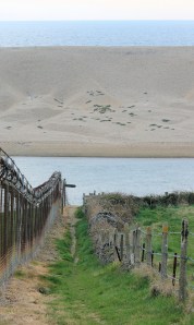 industrial area fencing, Chesil Beach, Ruth on her coastal walk