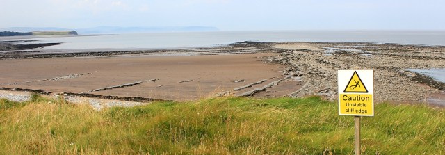 warning signs, Cliffs at Hinkley Point, Ruth walking the Somerset coast