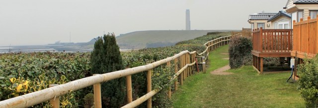 17 caravan park, power station ahead, Ruth on the Wales Coast Path