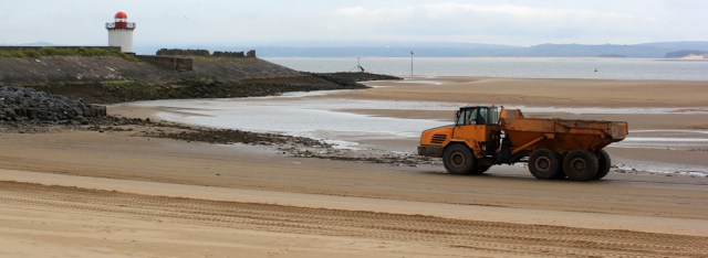 a05 removing sand from the beach, Burry Port, Ruth on her coastal walk in Wales