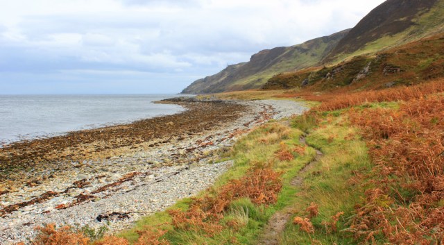 32 Millstone Point ahead, Ruth walking the north shore of Arran