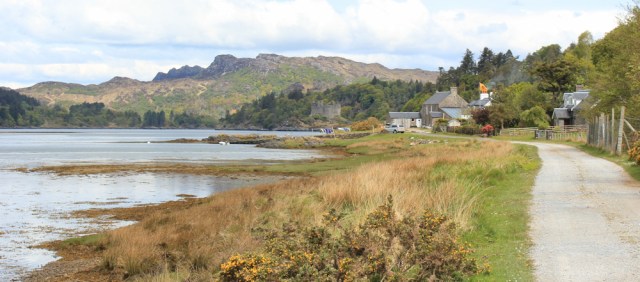 24 houses and castle ahead, Ruth walking towards Tioram Castle, Scotland