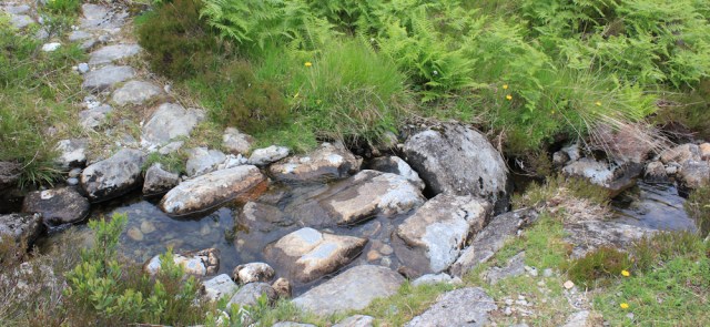 35 streams with stepping stones, Ruth walking the coast of Knoydart, Scotland