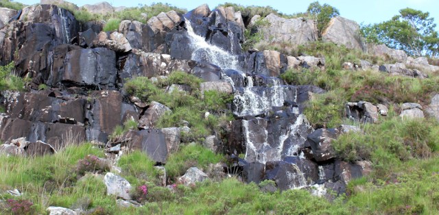 58 waterfalls beside path to Kyle, Ruth hiking the Scottish coast