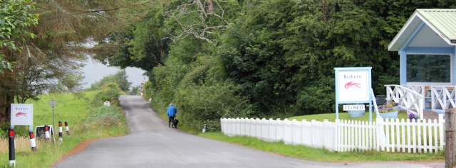 Ruth standing outside the Kishorn shop, walking the coast of Scotland